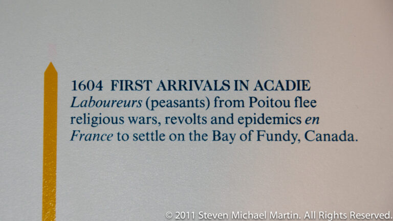 A museum chronology panel labels 1604 as the first arrivals in Acadie and describes settlement on the Bay of Fundy.