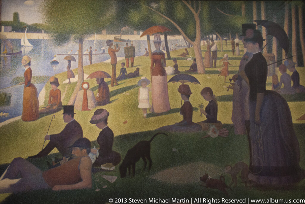 Seurat’s pointillist painting shows figures resting beneath trees and umbrellas beside a river.