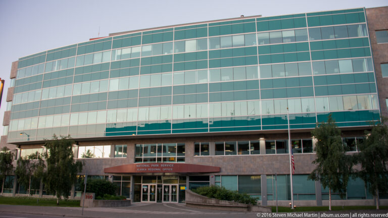 The glass façade and stone entrance of the National Park Service Alaska Regional Office in Anchorage.