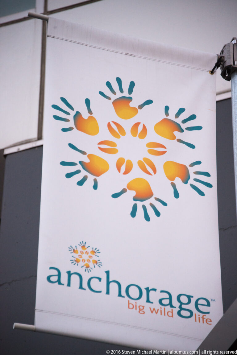 A white sign panel displays the Anchorage Big Wild Life logo in teal and orange.