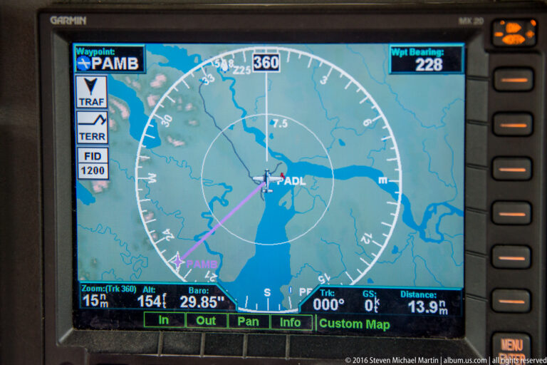 Cockpit map display with a magenta route line, compass rose, ADL label, and navigation data.