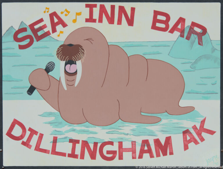 Illustrated walrus holding a microphone beneath the words “Slap Happy Bar” and “Dillingham AK.”