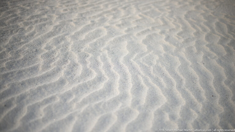 Close parallel ridges and shallow troughs form a repeating pattern across pale sand.