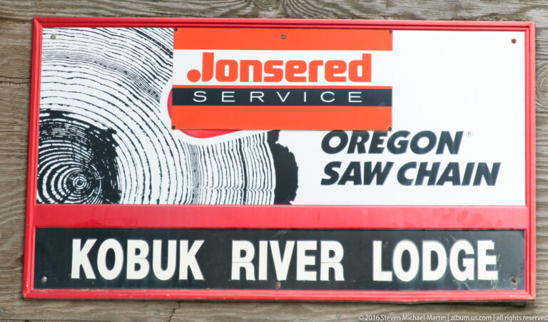 A red-framed sign reads “Kobuk River Lodge” below “Jonsered Service” and “Oregon Saw Chain.”