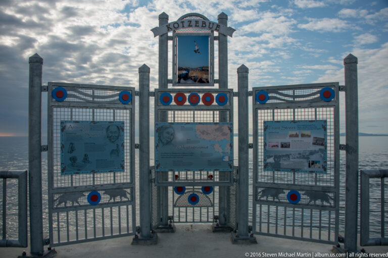 Three information panels sit within a symmetrical metal gateway decorated with blue and red circles.