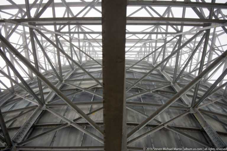 A central beam divides dense steel braces beneath a White Alice reflector.