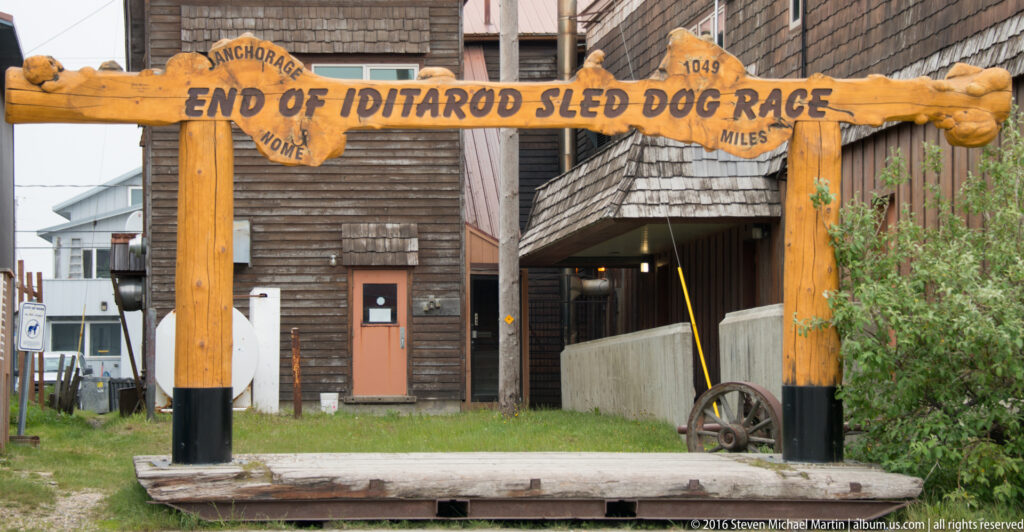 A wooden gateway over a Nome street reads “End of Iditarod Sled Dog Race.”
