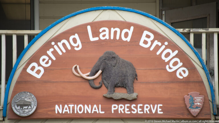 A wooden Bering Land Bridge National Preserve sign features a raised mammoth and agency emblems.