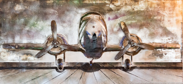 A wall mural shows a head-on twin-engine propeller plane against a mottled, weathered background.