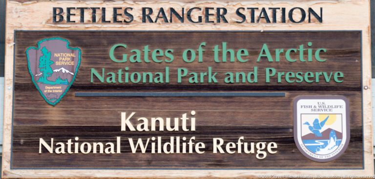 A wooden sign names Gates of the Arctic National Park and Preserve and Kanuti National Wildlife Refuge.