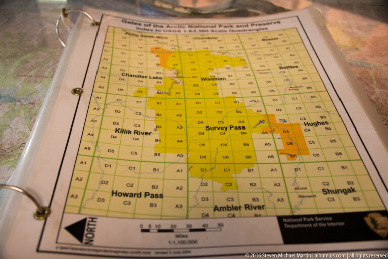 A yellow grid map in a binder labels Chandler Lake, Killik River, Survey Pass, and Ambler River.