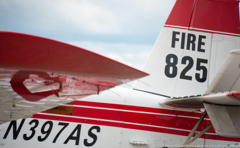 Close crop of a red-and-white airplane tail marked FIRE 825 and registered N3974AS.