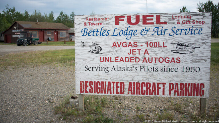 Weathered Bettles Lodge and Air Service sign advertising fuel, lodging, a gift shop, and aircraft parking.