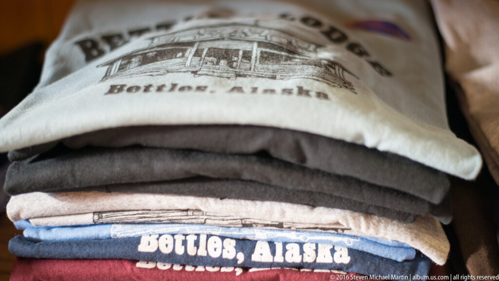 Folded sweatshirts are stacked together, including a blue one printed with “Bettles, Alaska.”