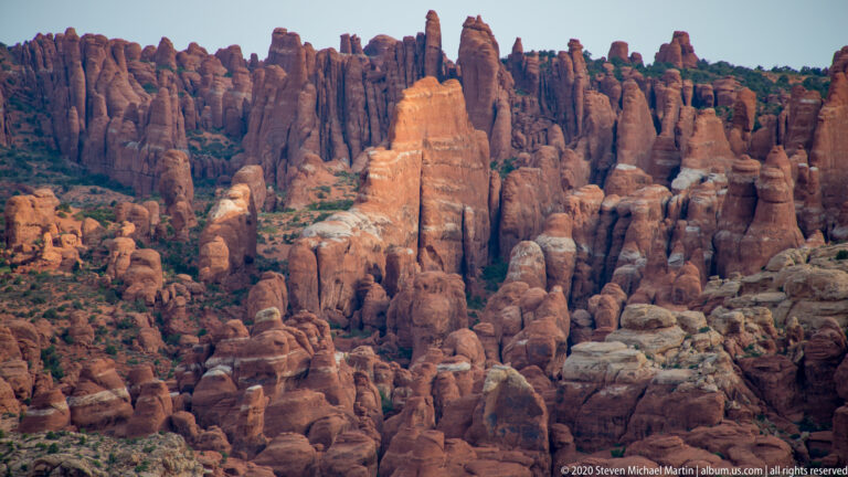 A dense field of red sandstone fins and towers fills the frame, with a lighter central spire.
