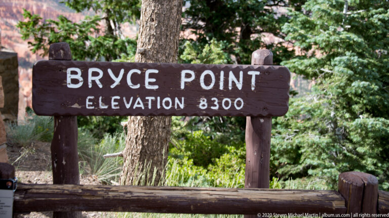 Bryce Point sign displays an elevation of 8,300 feet against trees and foliage.