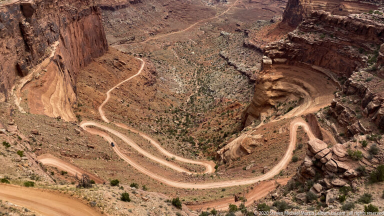 Shafer Trail switchbacks descend a steep sandstone wall into the canyon.