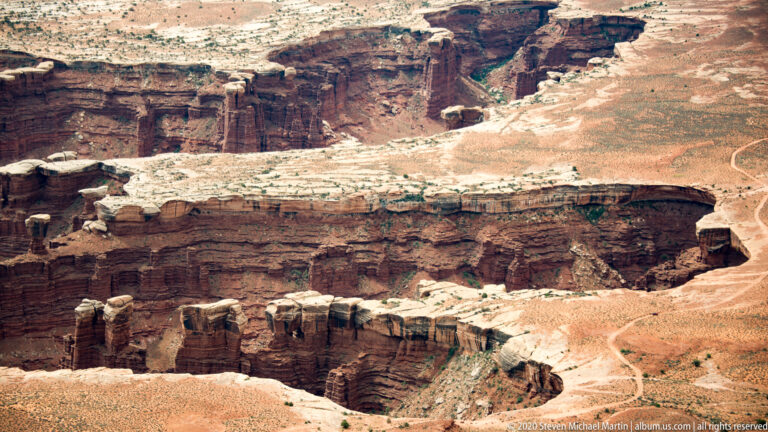 Pale rim rock overlooks tightly packed red canyon walls and narrow branching ravines.