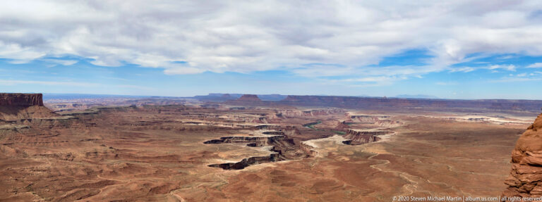 Layered mesas and shadowed ravines fill a wide canyon panorama.