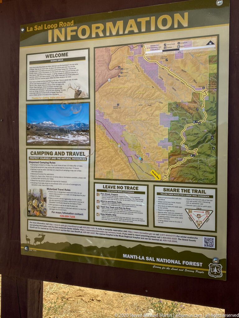 A framed Forest Service board displays a map and panels about camping, Leave No Trace, and sharing trails.