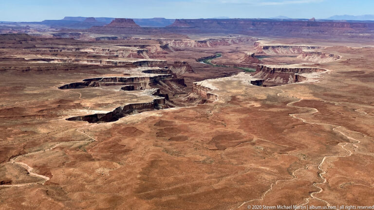 A maze of mesas and ravines spreads across a rust-colored plateau.