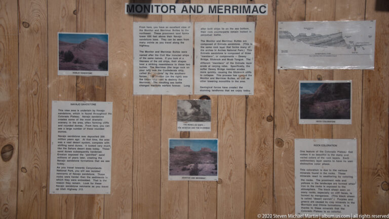 A wood wall holds an interpretive exhibit about the Monitor and Merrimac buttes.