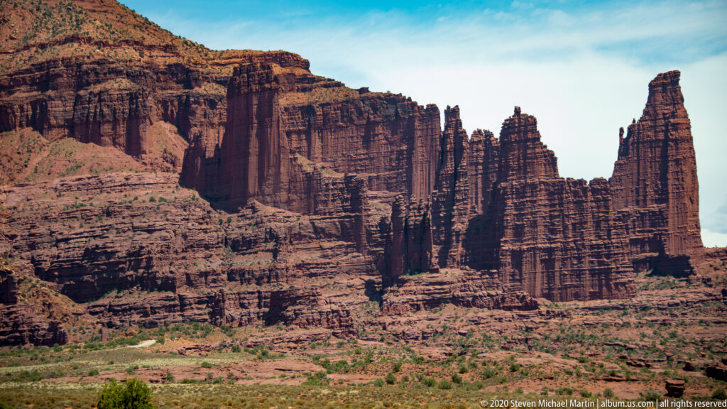 Tall sandstone fins and layered rock walls rise with narrow fissures between their vertical forms.