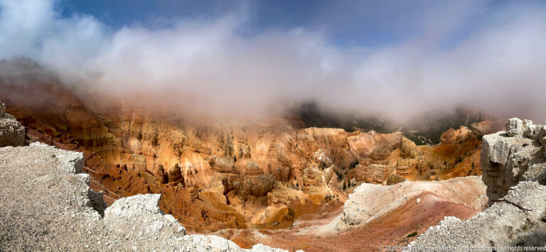 Low clouds cover the upper rim of Cedar Breaks while orange hoodoos remain visible below.