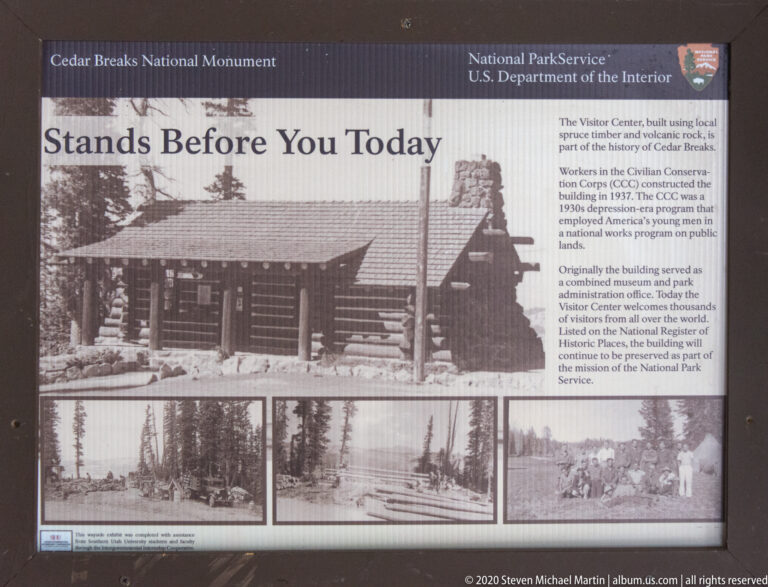 A history panel titled “Stands Before You Today” displays archival photographs of a log building.