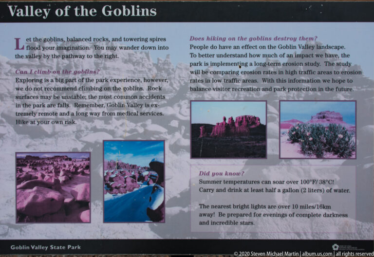 A Valley of the Goblins sign explains visitor safety and erosion beside several photographs of the formations.