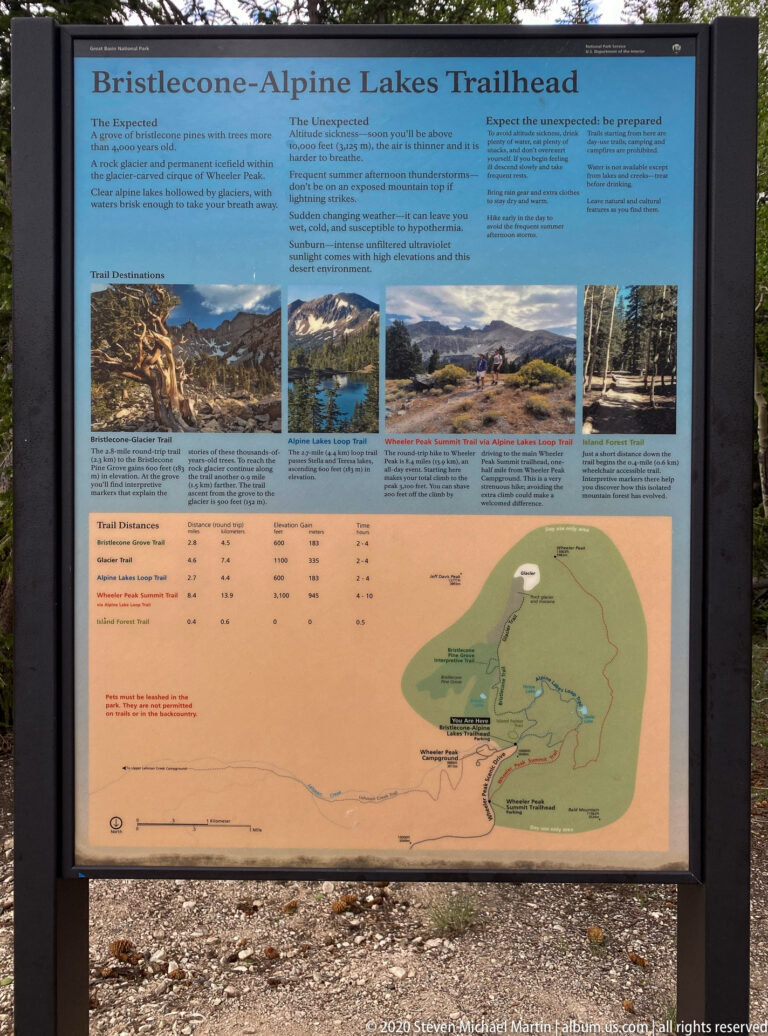 A trailhead board displays bristlecone pine information, trail details, photographs, and a large route map.
