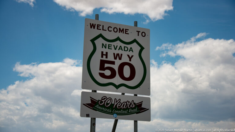 A Nevada Highway 50 welcome sign stands above a “30 Years” America’s Loneliest Road panel.