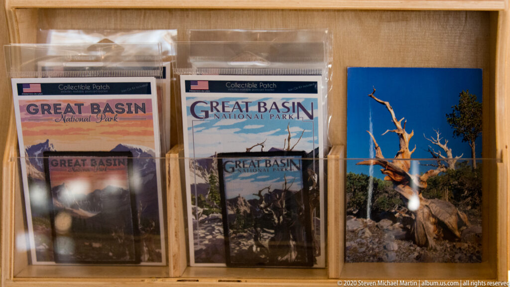 Great Basin National Park patches and printed keepsakes are arranged behind reflective glass.
