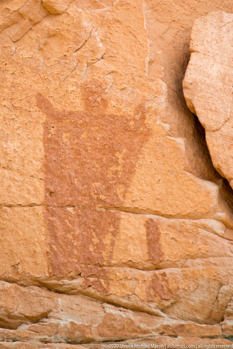 A narrow shadowed crevice separates smooth orange sandstone slabs.