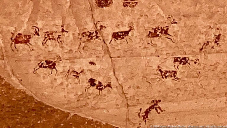 Small animal-like forms cross the upper sandstone, with grouped marks and a larger humanlike figure below.