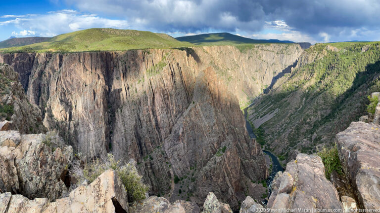 Rocky ledges frame steep canyon walls and the Gunnison River far below.