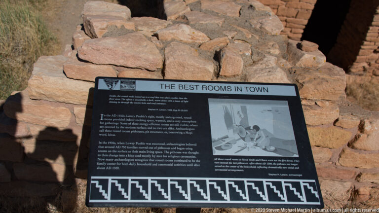 A sign titled “The Best Rooms in Town” stands among stone ruins beside an interior scene illustration.