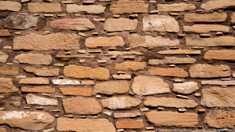 Flat sandstone blocks form uneven horizontal courses across a close wall view.