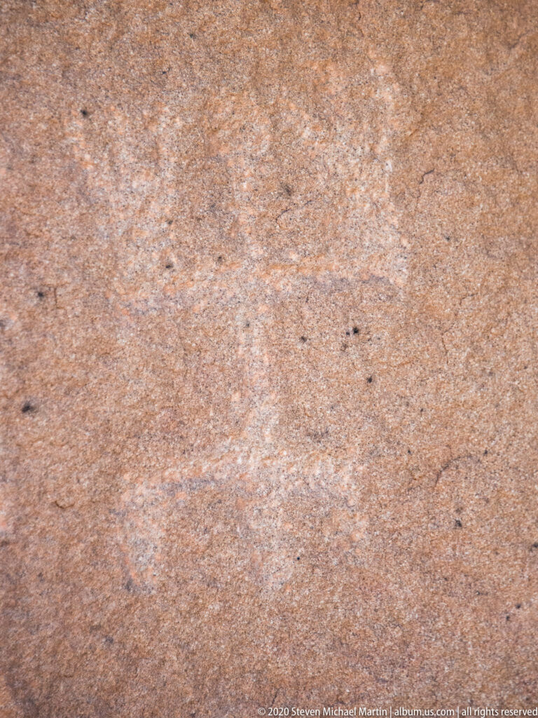 A close sandstone surface shows fine grain and dark speckles without a distinct marking.