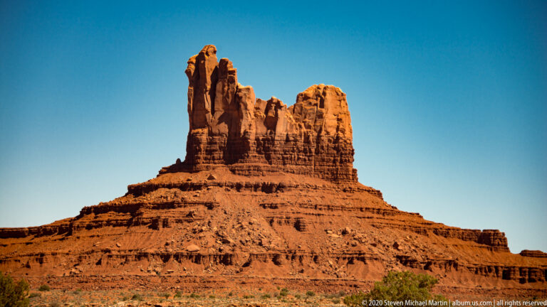 Two uneven rock towers rise from a broad, stepped red sandstone base.