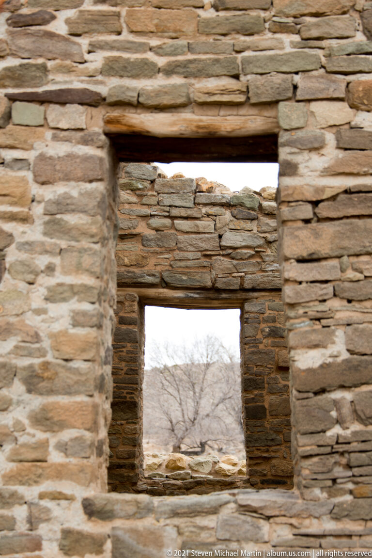 Two vertically aligned rectangular openings with timber lintels in a finely coursed stone wall.