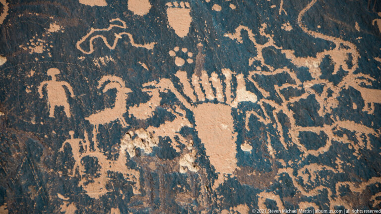 A broad human-like figure extends its arms beneath radiating lines, with smaller figures nearby.