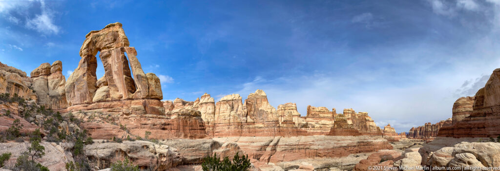 A long canyon corridor of layered sandstone extends from Druid Arch at the far left.