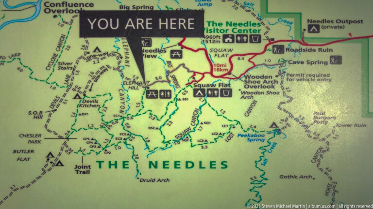 Close view of a printed Needles district map with a “You Are Here” marker near Elephant Hill and labeled trails.