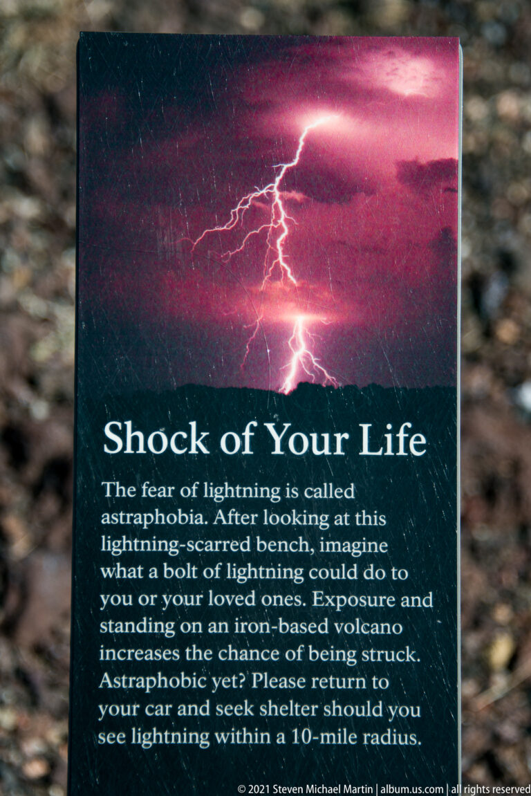 A dark interpretive panel titled “Shock of Your Life” displays a lightning image and a warning about summit storms.