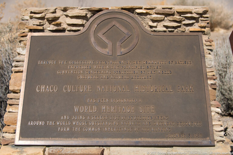 A bronze plaque names Chaco Culture National Historical Park as a World Heritage Site, mounted in stonework.