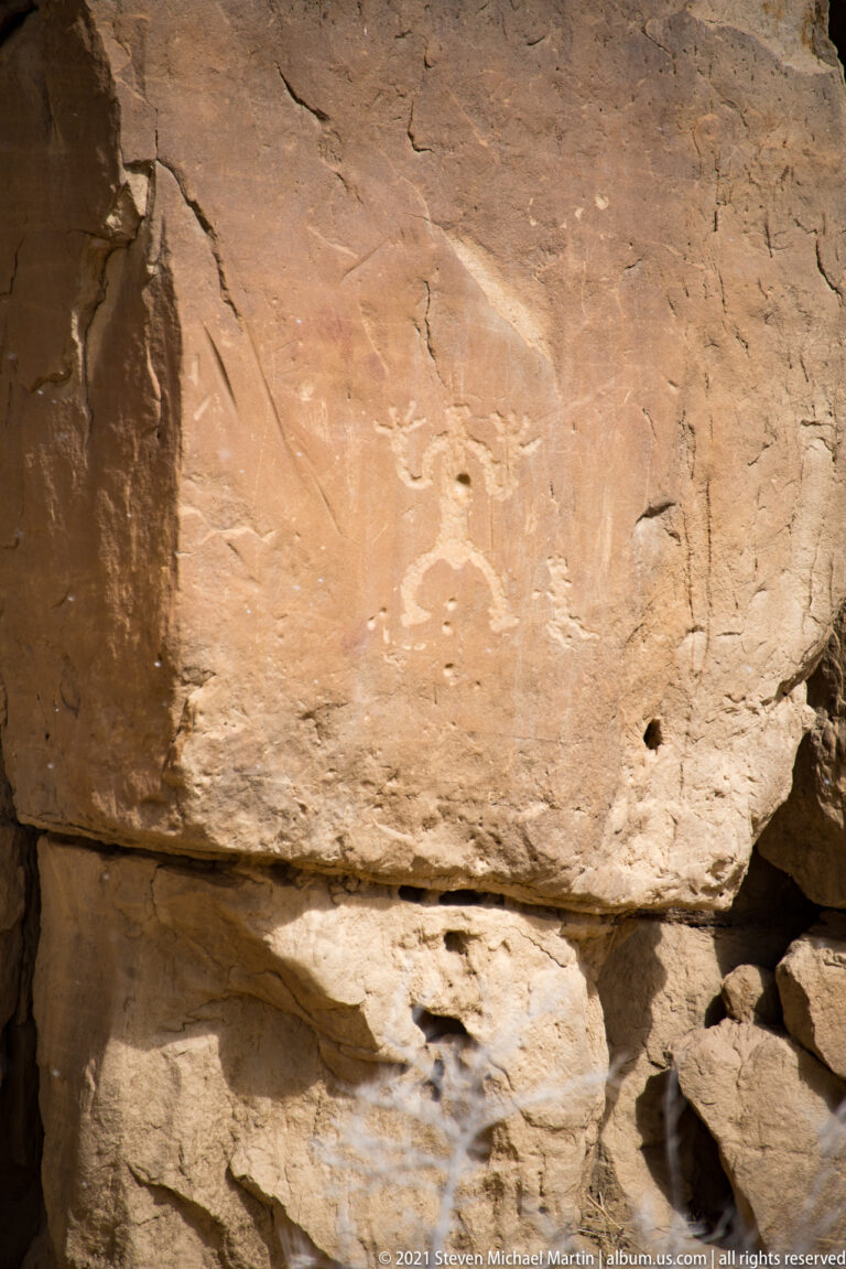 A broad sandstone ledge projects above a dark recess, with fractured rock surfaces in close view.