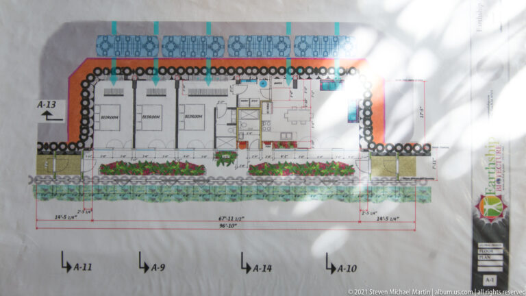 A floor plan shows rooms inside a repeated tire-wall perimeter, with planting beds along one side.