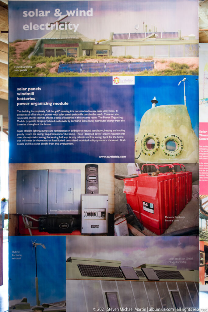 A Wind Electricity panel shows a small turbine, solar equipment, batteries, and an Earthship exterior.
