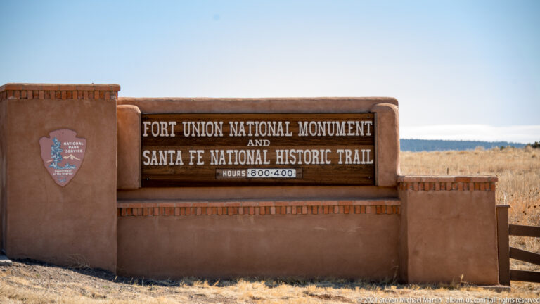 A stucco wall sign names Fort Union National Monument and the Santa Fe National Historic Trail.